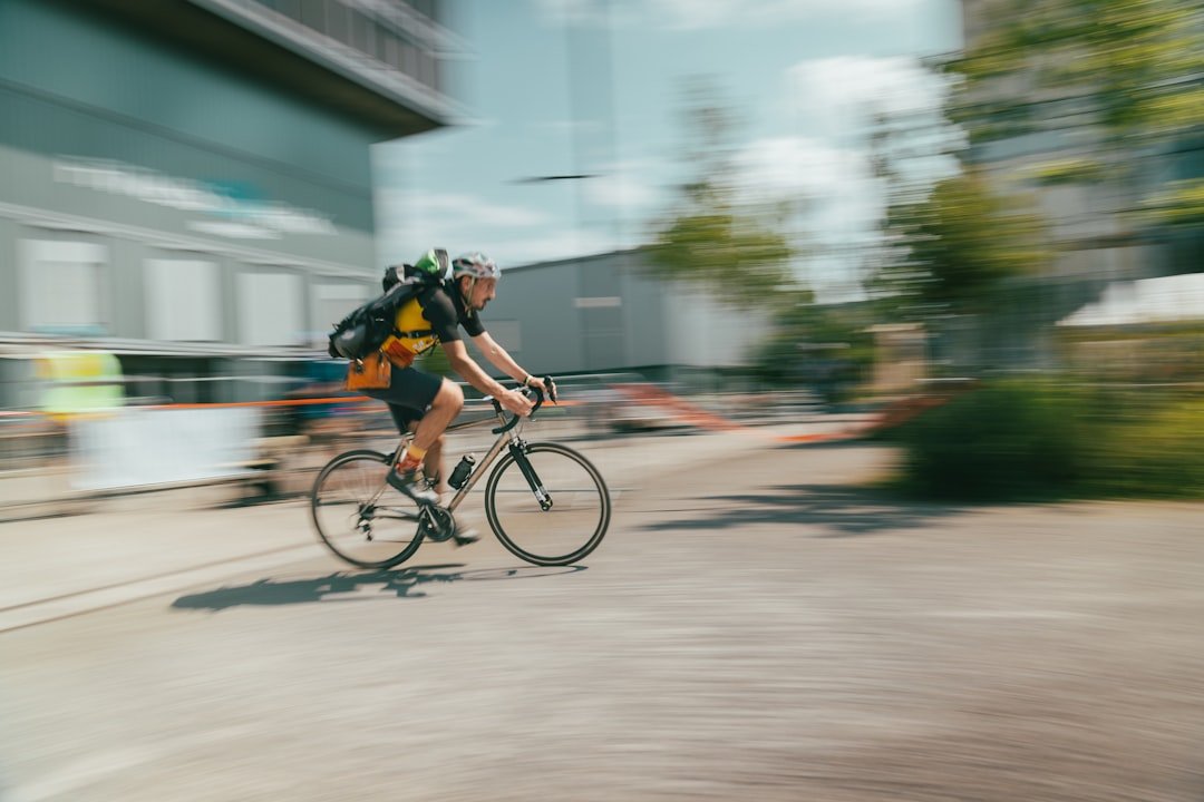 A blurry photo of a bicyclist riding down a street