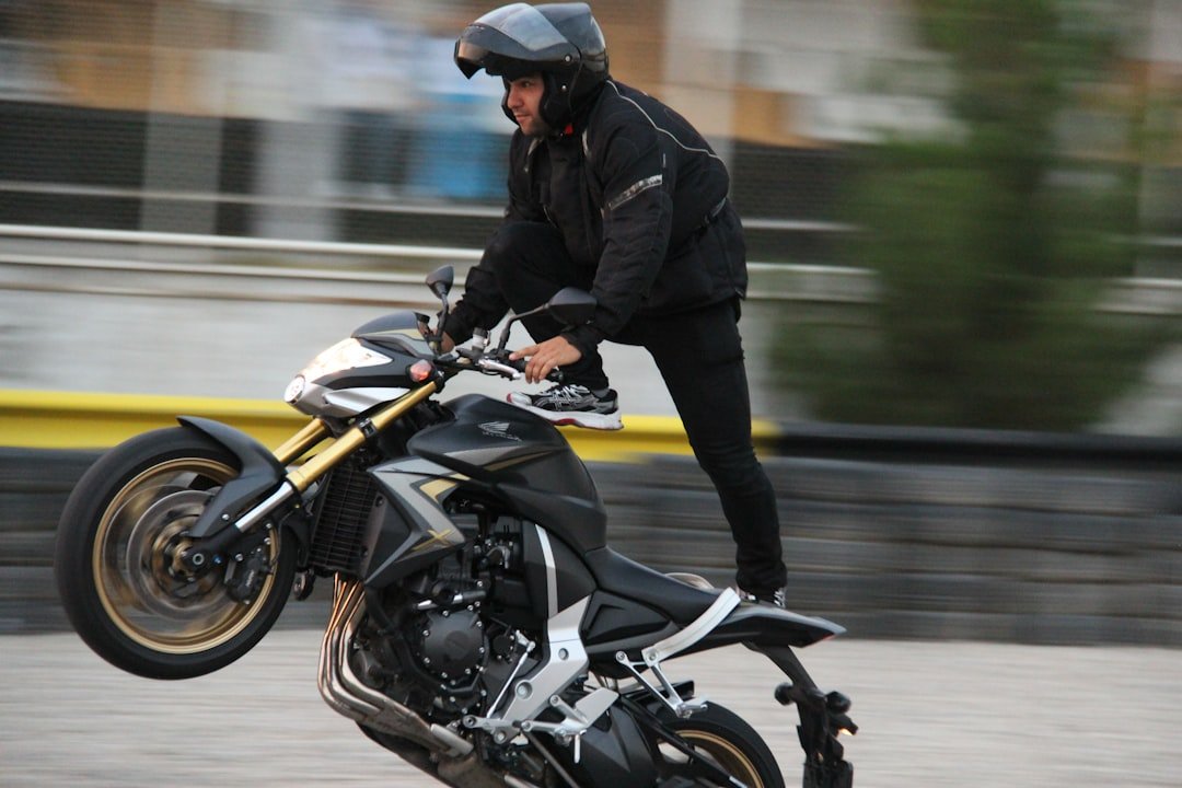 man in black leather jacket riding black motorcycle