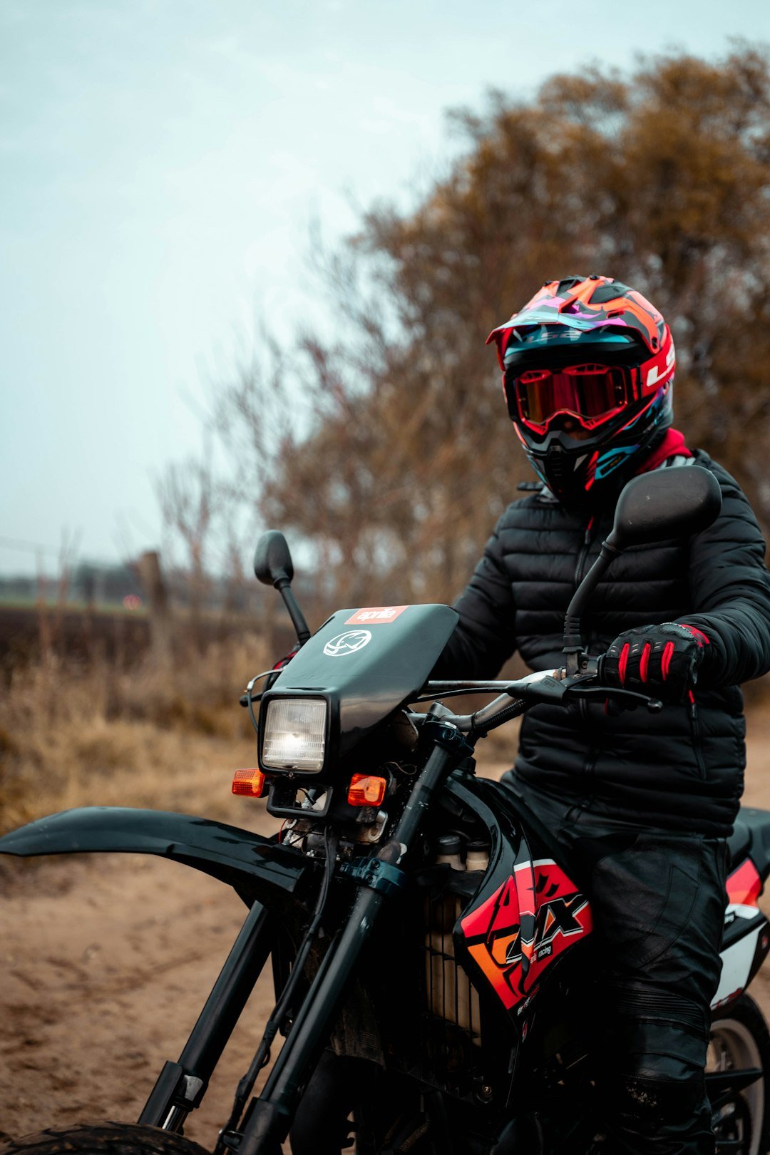 Person in helmet riding a dirt bike outdoors