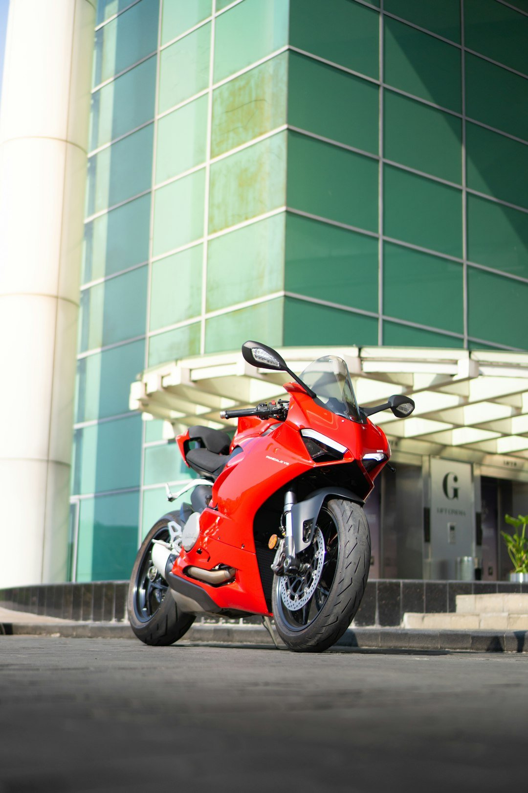 a red motorcycle parked in front of a building