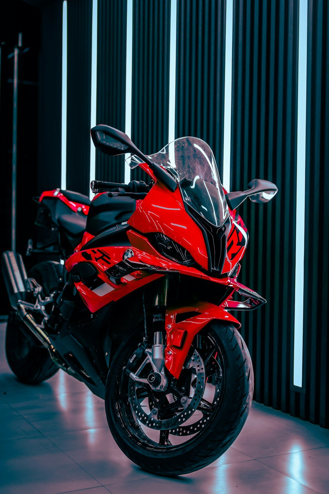 A red and black motorcycle parked in a garage