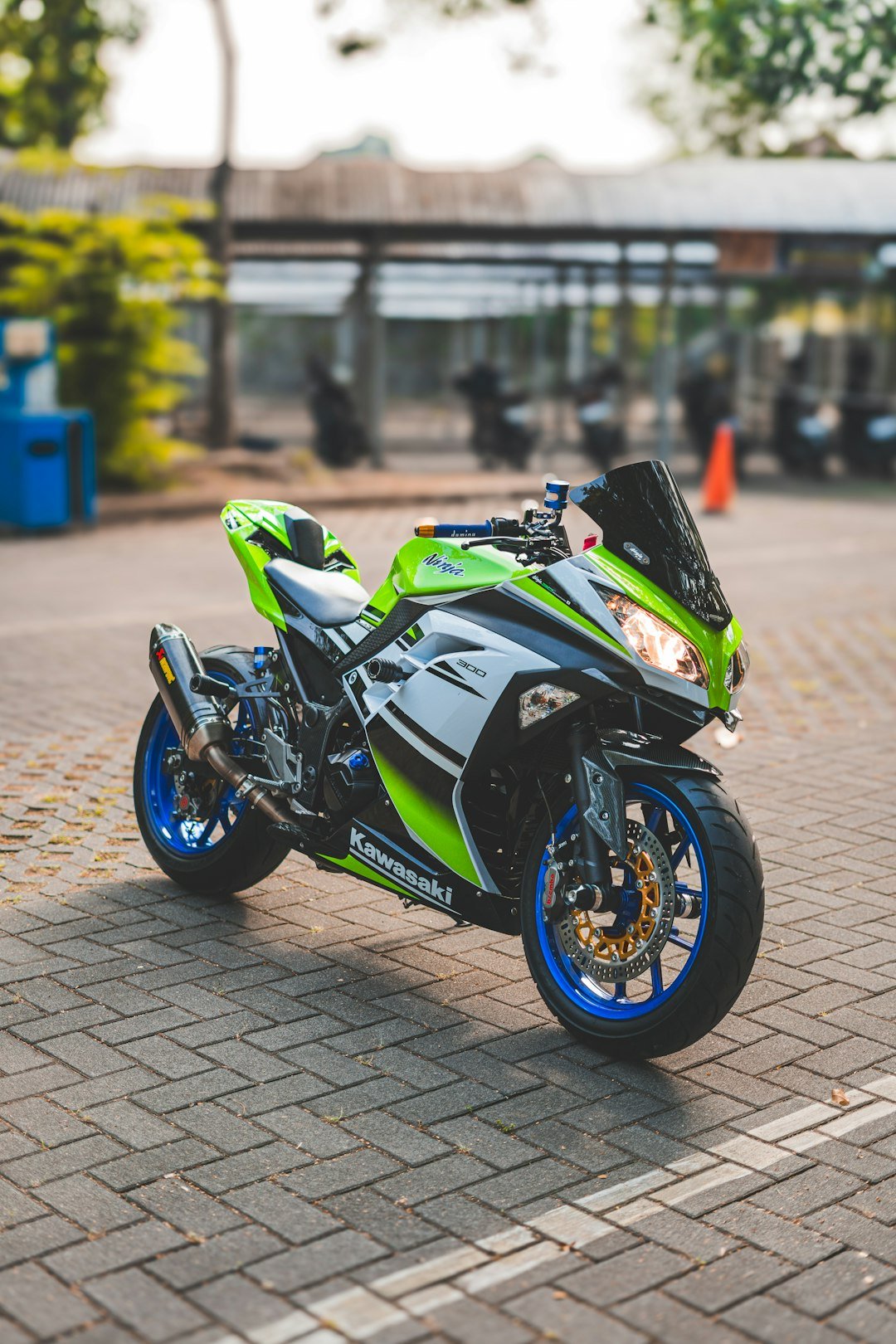 A green and black motorcycle parked on a brick road