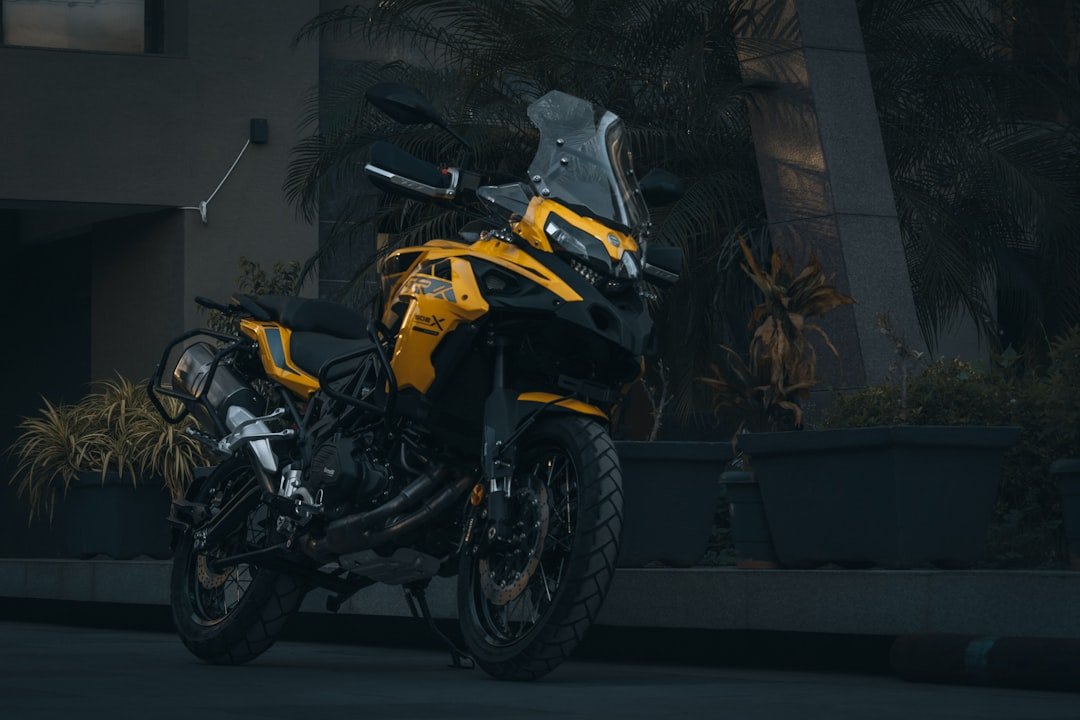 a yellow and black motorcycle parked in front of a building