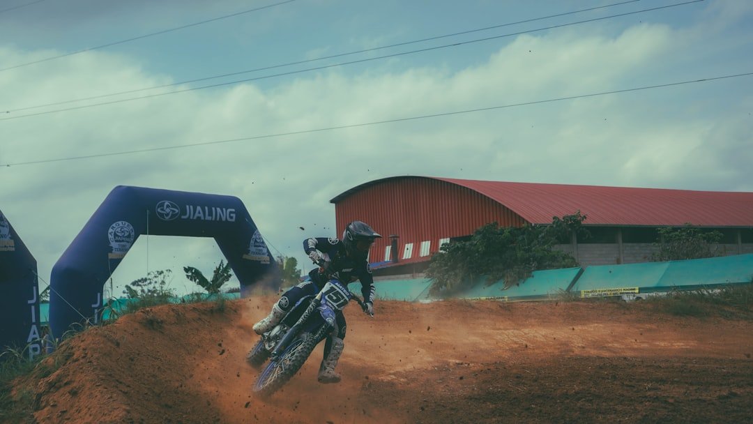 A man riding a dirt bike on top of a dirt field