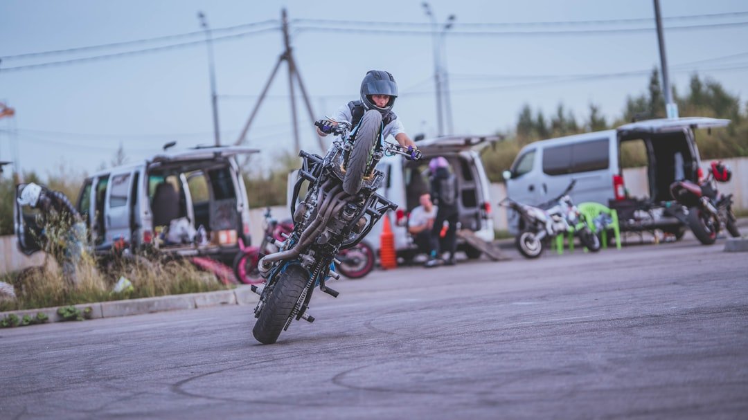 A man riding a motorcycle on top of a parking lot
