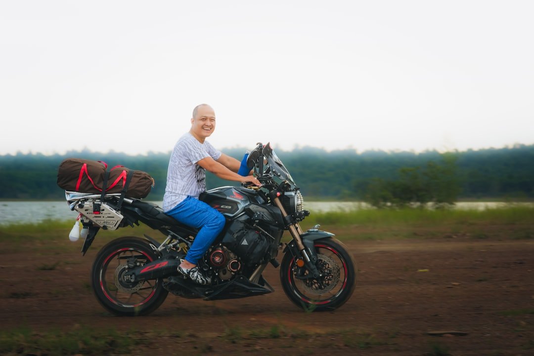 Bald person riding a motorcycle with luggage