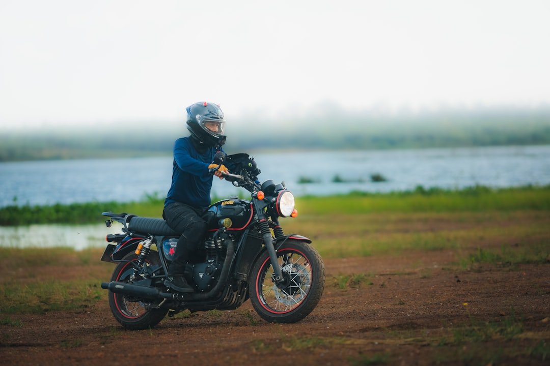 Person riding a motorcycle near a lake
