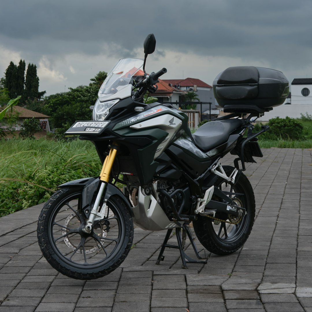 A dark green adventure motorcycle with a storage box.