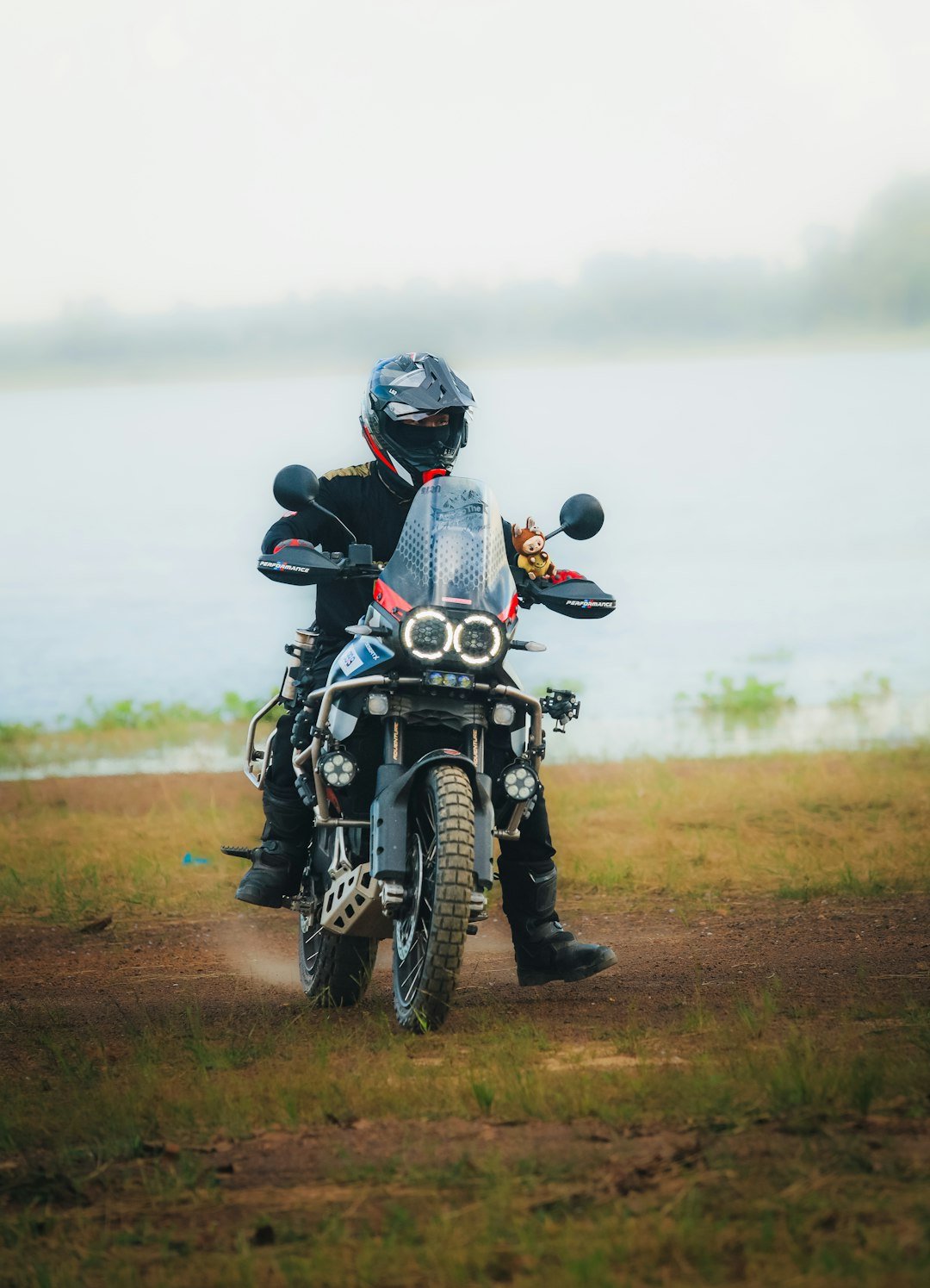 Rider on motorcycle near a body of water