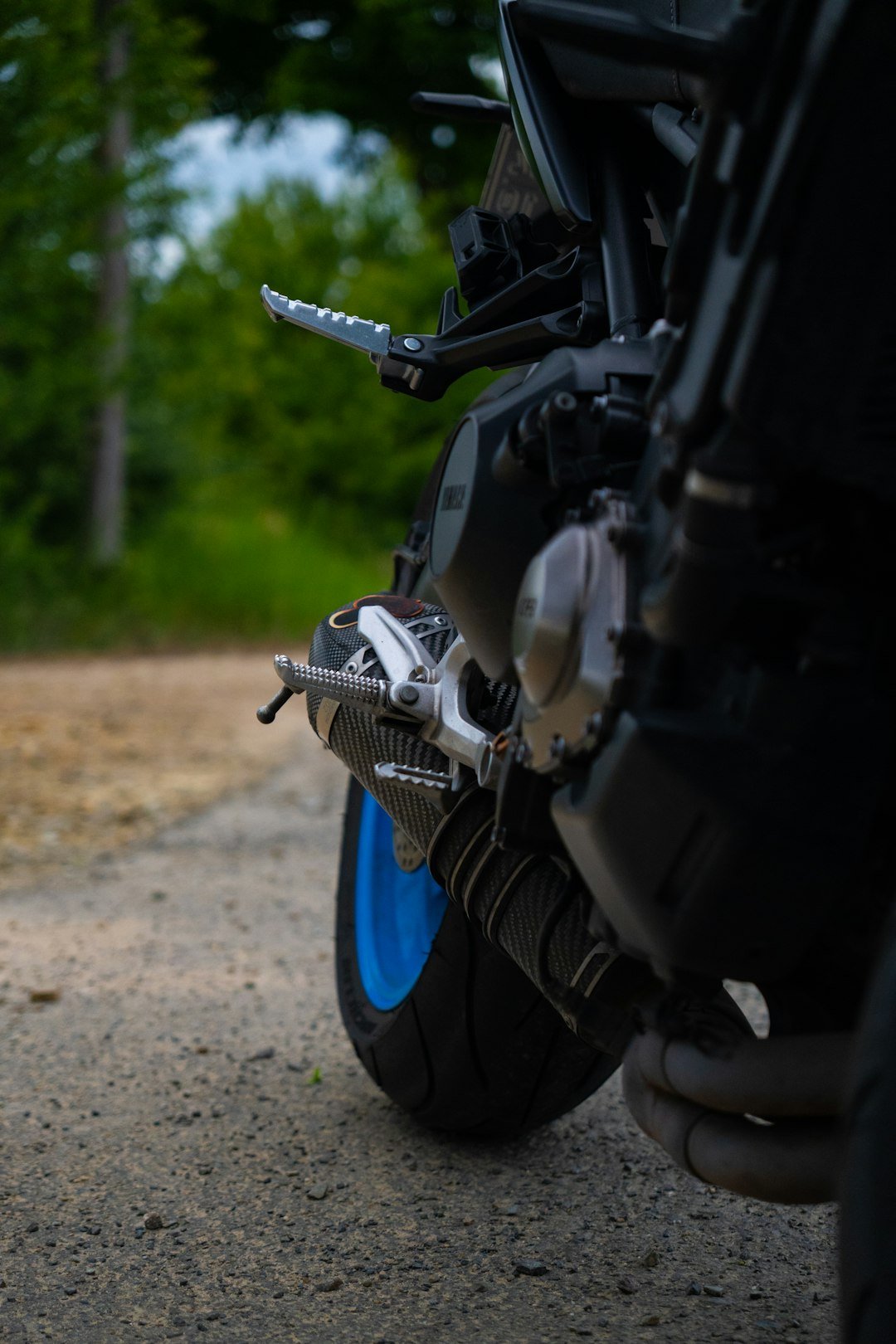 Close-up of a motorcycle's exhaust and wheel