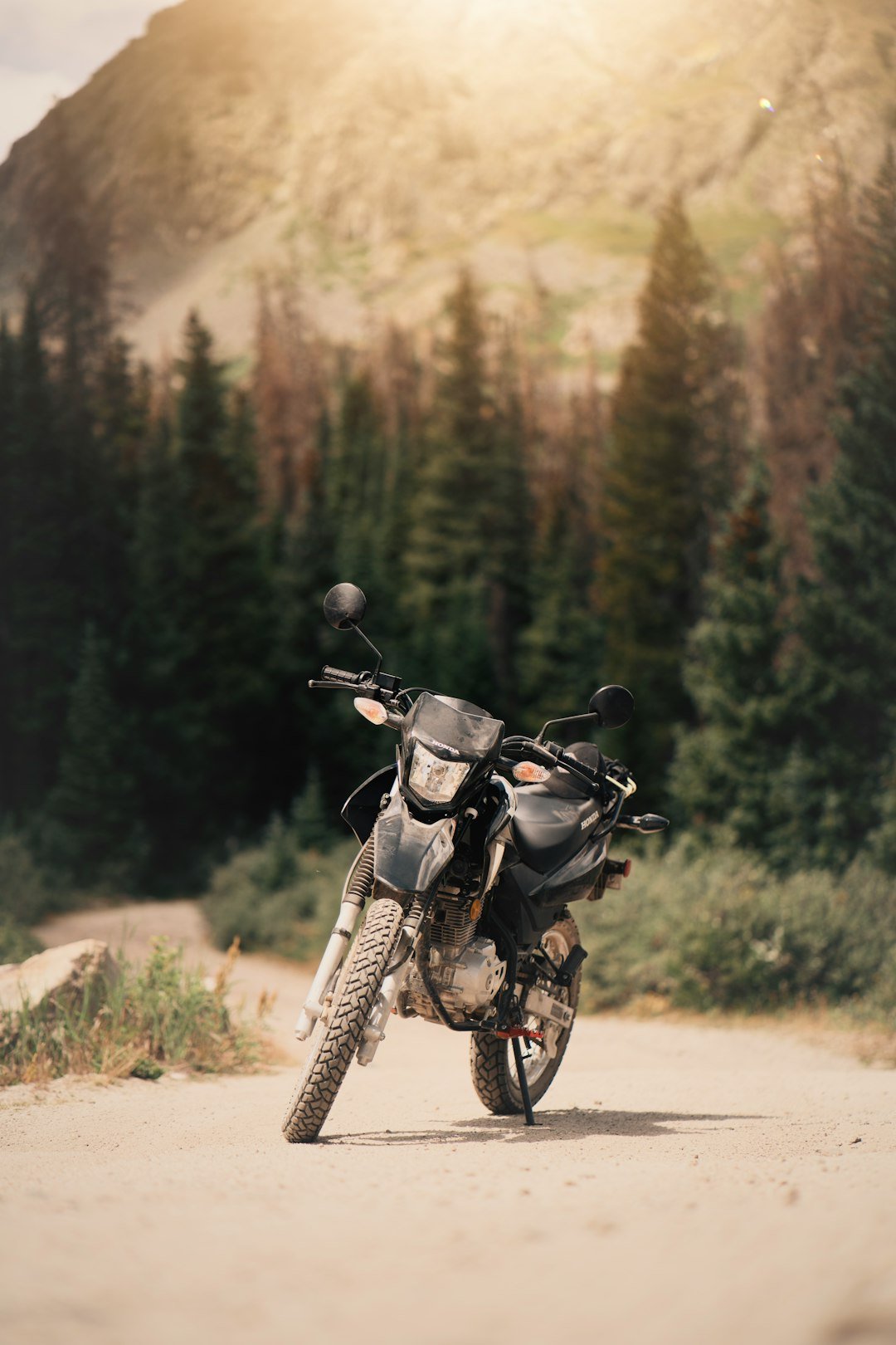 Dirt bike parked on a mountain road with trees