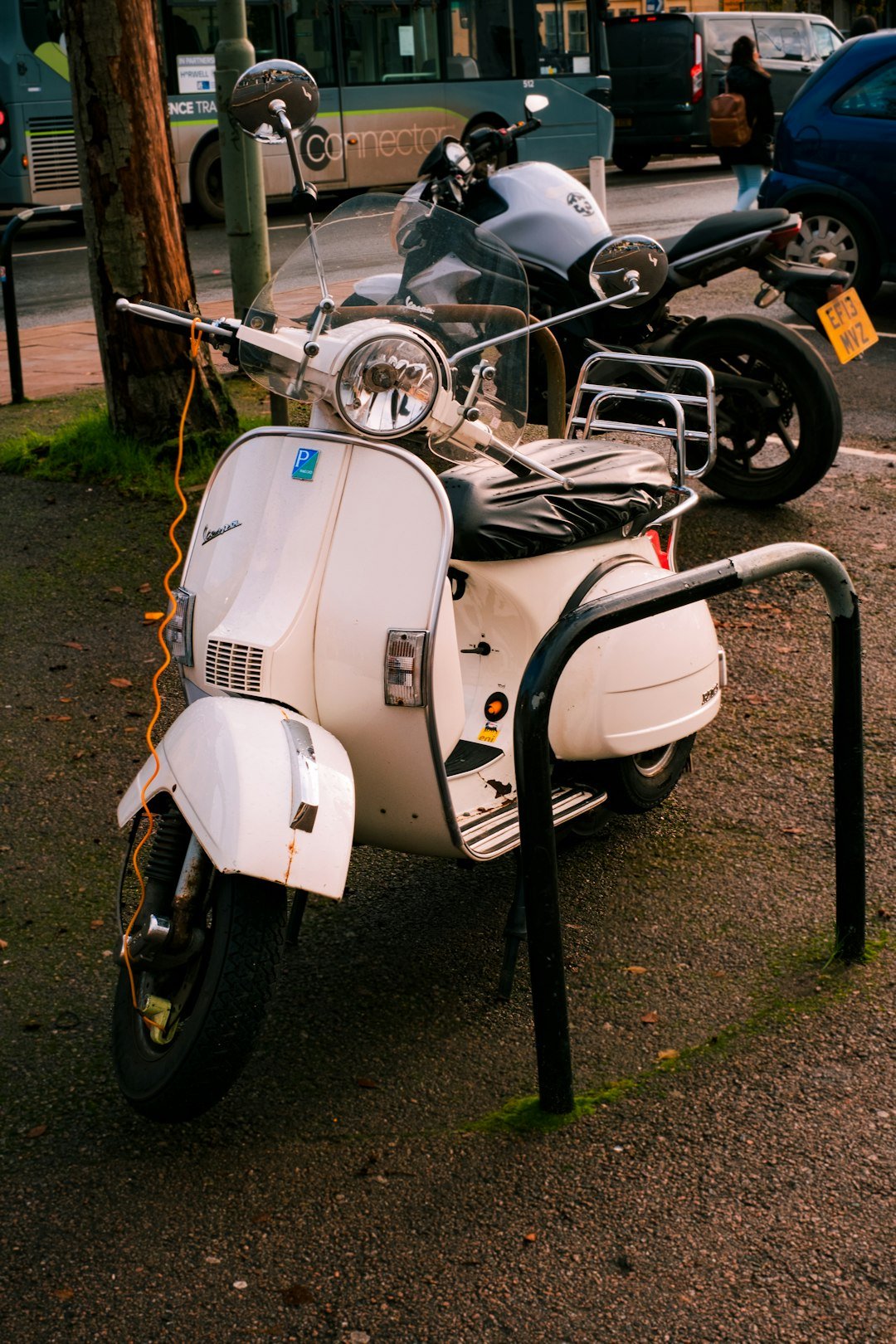 a white scooter parked on the side of the road
