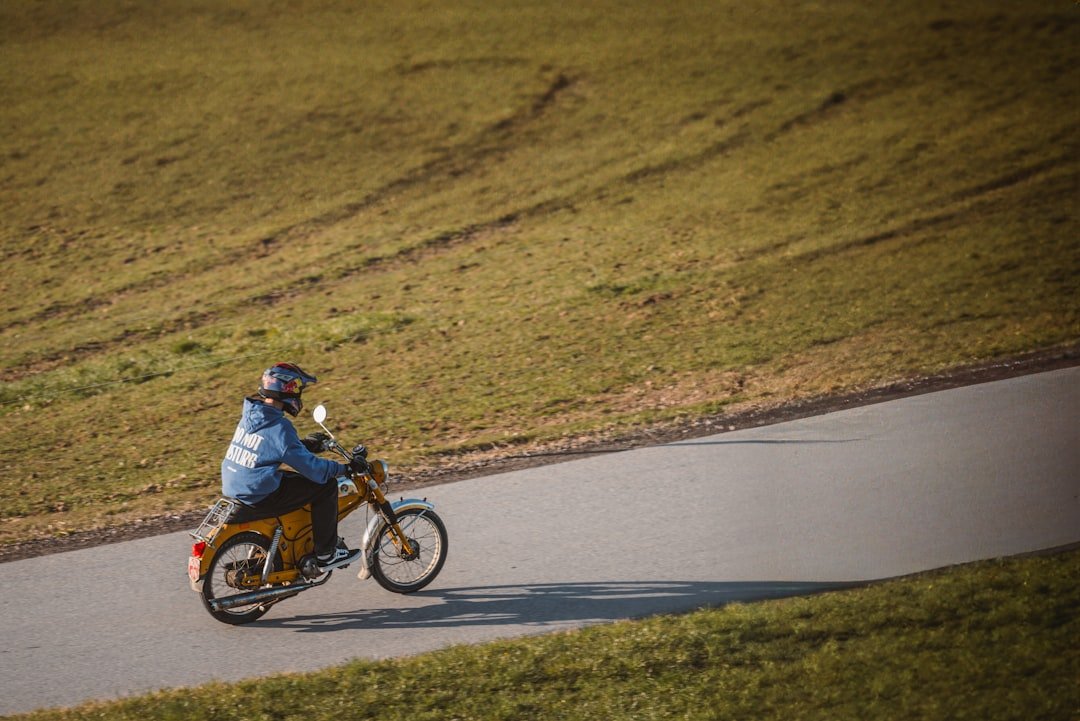 Person rides a motorcycle down a country road.