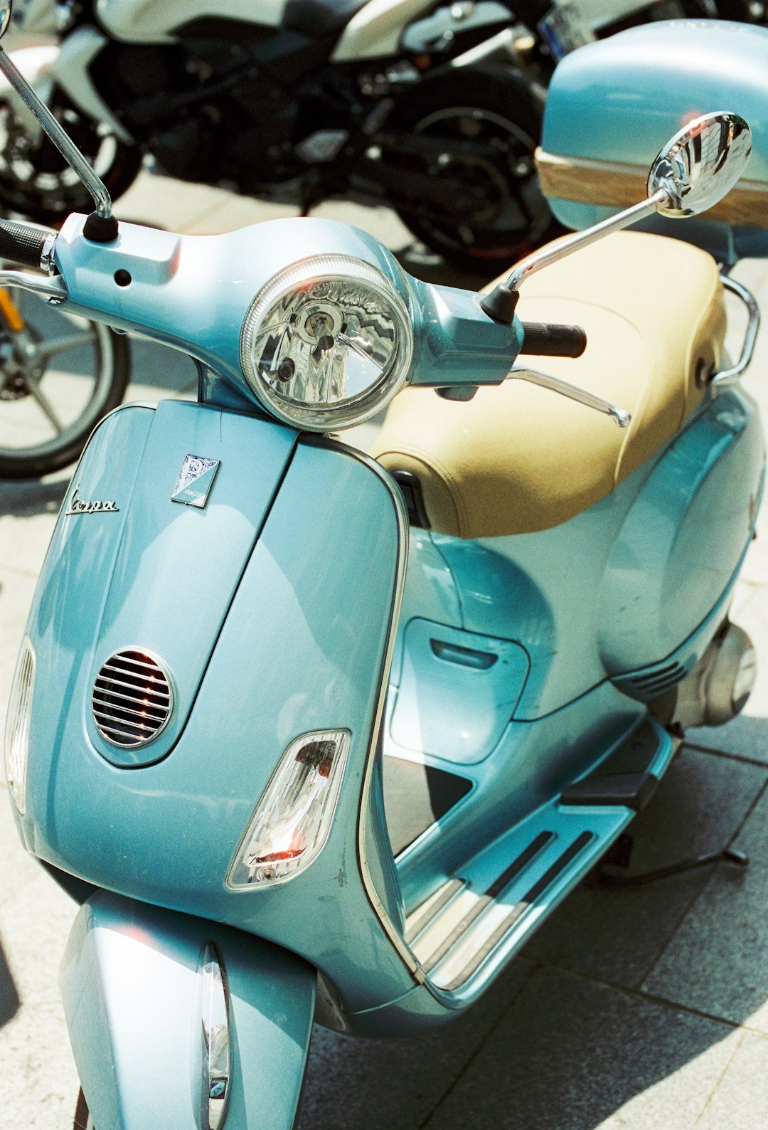 A light blue vintage scooter parked outdoors.