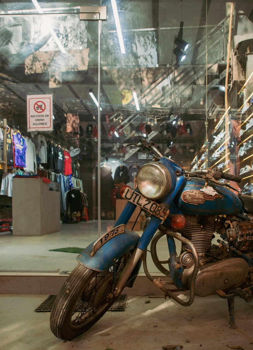Blue vintage motorcycle parked outside a store.