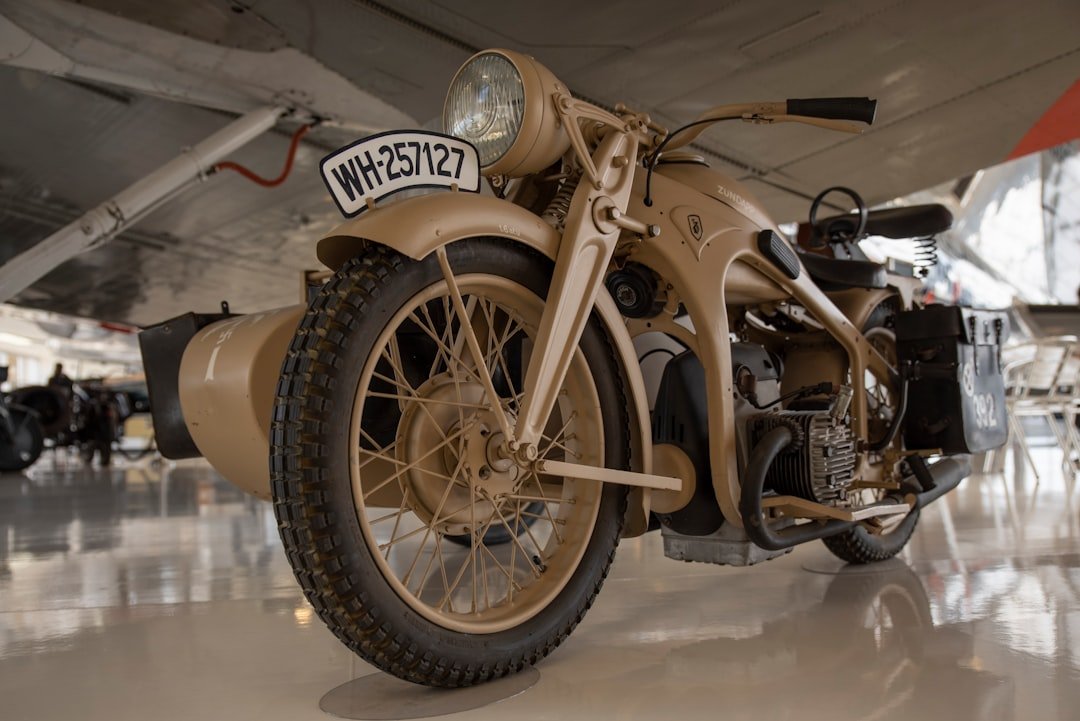 a tan motorcycle parked inside of a hangar