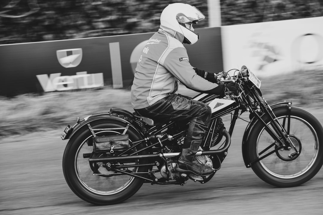 Man in helmet riding vintage motorcycle on road