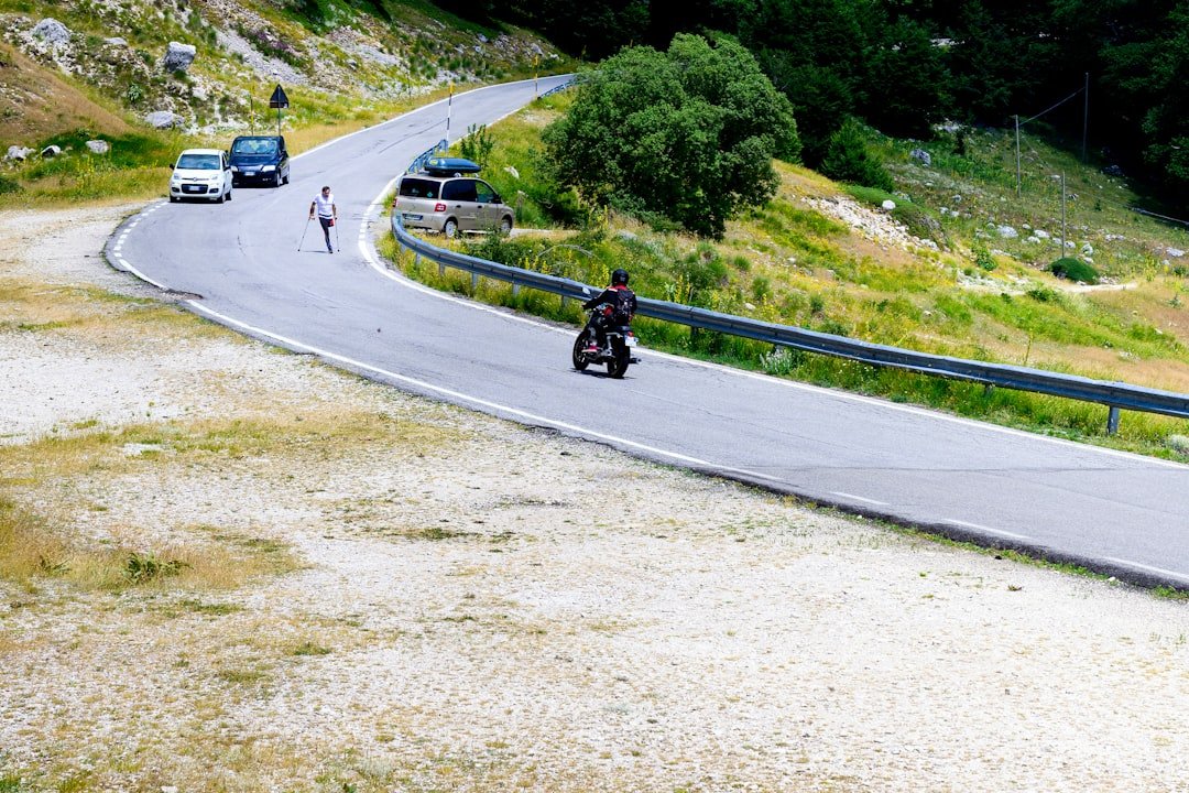 Motorcyclist and cars on a winding mountain road