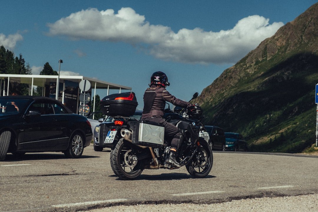 Motorcyclist riding on a mountain road with cars