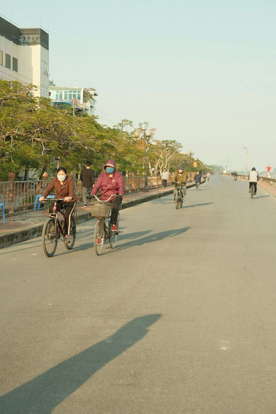 A couple of people riding bikes down a street