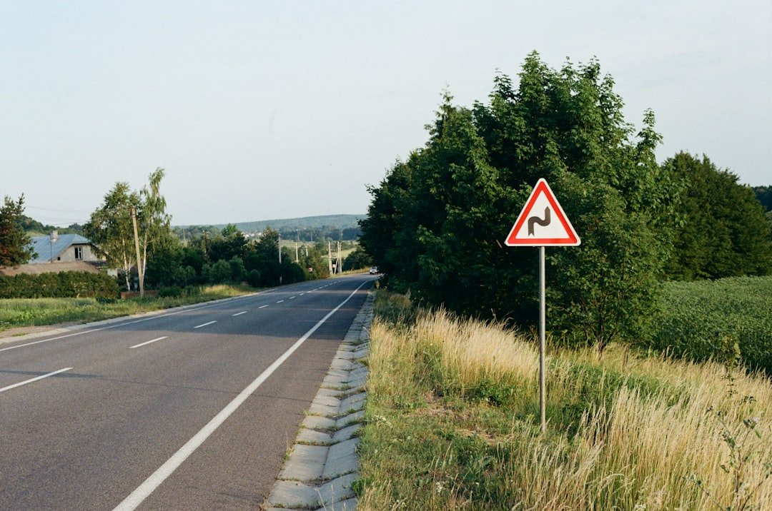 a red and white sign sitting on the side of a road